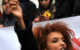 Une manifestante brandit un carton jaune contre le gouvernement lors d'une manifestation à Tunis le 12 janvier 2018 contre les mesures d'austérité.