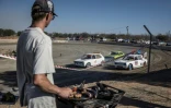 Un spectateur grille de la viande sur un braai (barbecue) devant une course de voiture sur l'ovale de terre de l'enclave afrikane en Afrique du Sud, le 30 mai 2026.