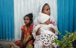 Une mère et ses enfants déplacés par les violences dans la région éthiopienne du Tigré, attendent de recevoir une aide à Mekele, le 22 juin 2021