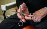 Le coiffeur Roger Amilhastre, âgé de 90 ans, tient une paire de ciseaux dans son salon à Saint-Girons, en Ariège, le 16 avril 2024