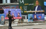Un policier irakien à un check-point devant des affiches électorales, le 11 mai 2018 à Mossoul, en Irak