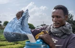 L'agriculteur Habib Bobasso remplit le réservoir de son pulvérisateur de pesticide avant de l'appliquer sur les plants d'oignons de son champ le long des rives du lac Dembel, le 20 mai 2025 à batu, en Ethiopie