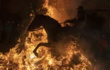 Un cavalier saute par dessus un brasier dans le village espagnol de San Bartolome de Pinares pendant les traditionnelles "Luminarias", le 16 janvier 2022