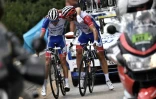 Le Français Thibaut Pinot (g) réconforté par un équipier lors de son abandon dans la 19e étape du Tour de France le 26 juillet 2019