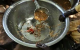 Des mains posées sur une assiette presque vide, servie à des familles dans le village de Merine Dakhar (Sénégal), le 29 mai 2008
