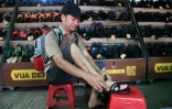 Un client essaie des sandales en caoutchouc dans une boutique, le 5 juillet 2022 à Hanoï, au Vietnam