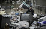 Un habitant ramasse les débris dans une rue inondée de Villeneuve-Saint-Georges le 25 janvier 2018