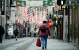 Une femme passe dans une rue piétonne et commerçante à Cologne, le 4 janvier 2021