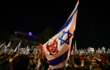 Des manifestants israéliens antigouvernementaux brandissent un drapeau national avec une photo du Premier ministre Benjamin Netanyahu, lors d'un rassemblement à Jérusalem, le 31 mars 2024