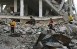 Des enfants palestiniens jouent dans les décombres d'un bâtiment détruit à Khan Younès, dans le sud de la bande de Gaza, le 10 décembre 2024