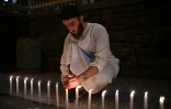 Un homme allume des bougies pour rendre hommage aux 49 victimes de l'attaque de deux mosquées à Christchurch, le 16 mars 2019