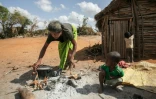 Helmine Monique Sija, la cinquantaine, fait bouillir du raketa (cactus) pour le manger avec sa fille Tolie, 10 ans, le 30 août 2021, dans le village d'Atoby, touché par la sécheresse et la faim, dans le sud de Madagascar