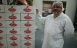 Georges Viana, propriĂ©taire de la biscuiterie, montre dans l'usine de DĂ©mouville, le 26 janvier 2016 les cartons de madeleines Jeannette prĂȘts Ă ĂȘtre expĂ©diĂ©s
