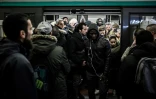 Des voyageurs sortent d'une voiture du métro parisien bondée tandis que d'autres attendent pour y entrer, en décembre 2019 lors d'une grève à la RATP 