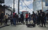 Des manifestants se tiennent près d'une barricade de fortune le 3 octobre 2025 à Antananarivo