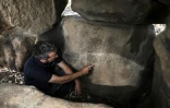 Uri Berger, archéologue de l'Autorité israélienne des antiquités, montre des gravures découvertes dans un dolmen du Golan syrien, occupé par Israël, le 13 juillet 2020