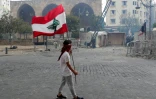 Un homme porte un drapeau libanais lors d'une manifestation, le 8 août 2020 à Beyrouth, pour demander des comptes à la classe politique après la terrible explosion ayant dévasté une partie de la capitale et fait plus de 150 morts