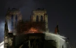 Des pompiers arrosent la toiture de la cathédrale Notre-Dame dans la nuit du 15 au 16 avril 2019, à Paris.