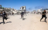 Des Palestiniens courent pour se mettre à l'abri lors d'une frappe de drone israélien à Jabalia, dans le nord de la bande de Gaza, le 23 mai 2025