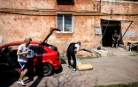 Dans un quartier régulièrement bombardé de Kharkiv, dans le nord-est de l'Ukraine, trois jeunes apportent de l'aide humanitaire, le 26 avril 2022