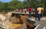 Des habitants se tiennent près d'un pont endommagé par les inondations, le 30 novembre 2025 à Kurunegala au Sri Lanka