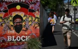 Un passant devant un mur peint à la station de trains de Redfern à Sydney, le 14 octobre 2023, jour du référendum sur les droits des Aborigènes en Australie