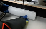 Un scientifique découpe une carotte glaciaire antarctique dans un laboratoire à Bruxelles, le 15 juillet 2025 en Belgique