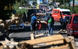 Un homme pousse un chariot rempli de vivres à travers le barrage de La Boucan qui bloque l'accès à Sainte-Rose (Guadeloupe), le 29 novembre 2021