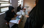 Une électrice dans un bureau de vote lors des élections des conseils provinciaux, le 18 décembre 2023 à Bagdad, en Irak