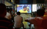 Des Chinois regardent le 8e de finale du Mondial entre le Brésil et le Mexique, dans une boutique de loto sportif à Shanghai, le 2 juillet 2018