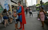 Leonardo Muylaert, le "Superman brésilien", avec une habitante du quartier de Tijuca, le 18 mars 2024 à Rio de Janeiro