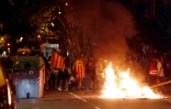 Des manifestants indépendantistes devant un feu allumé dans une rue de Barcelone le 1er octobre 2018
