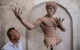 L'homme d'affaires W. Wong devant un buste de Bruce Lee, lors d'une exposition à Hong Kong, le 14 juillet 2023