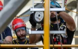 Le mineur Grzegorz Witek (g), participant au programme de formation pour techniciens d'éoliennes, lors d'un stage sur la sécurité, le sauvetage et l'évacuation en hauteur au centre de formation Vulcan à Szczecin, dans le nord-ouest de la Pologne, le 23 juin 2026