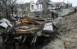 Des habitants passent près d'un tank russe détruit dans le village de Zalissya (Ukraine), au nord-est de Kiev, le 19 avril 2022