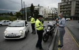 Contrôles policiers auprès d'un automobiliste et d'un piéton, à Athènes le 23 mars 2020