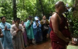 Un moine bouddhiste et des familles des enfants coincés dans une grotte prient à Chiang Rai, le 27 juin 2018