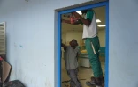 Un ouvrier répare la porte d'une classe du collège Zakia Madi, dans le village de Dembéni à Mayotte, le 22 janvier 2025