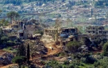 Un véhicule militaire israélien passe devant des maisons détruites par des frappes israéliennes dans le sud du Liban, vu depuis une position de l’autre côté de la frontière, en Haute Galilée, au nord d’Israël, le 7 mai 2026