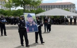 Des policiers portent un portrait de leur collègue Eric Masson lors d'une cérémonie d'hommage à Avignon le 11 mai 2021