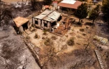 Une photo de drone prise le 4 juillet 2021 montre une maison détruite par les flammes dans le village d'Ora sur les montagnes du Troodos à Chypre