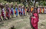 Une jeune fille massaï a grimpé dans un arbre pour assister à la parade des hommes lors de la cérémonie d'Eunoto, dans un village reculé près de Kilgoris, au sud-ouest du Kenya, le 18 août 2023