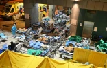 Des patients alités à l'extérieur du centre médical Caritas débordé par l'afflux de malades du Covid-19, le 16 février 2022 à Hong Kong