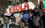 Des manifestants portent un cercueil sur lequel est écrit "Ebola" lors d'une marche contre un centre de quarantaine Ebola construit par les États-Unis sur la base aérienne de Laikipia, le 9 juin 2026 à Nanyuki, au Kenya