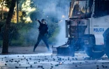 Un protestataire lance des pavés contre la police U lors d’une manifestation antigouvernementale à Tirana, le 17 octobre 2026 en Albanie