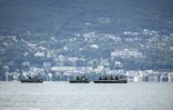 Des bateaux militaires suisses patrouillent sur le lac Léman au large de la ville d'Évian-les-Bains, avec l'Hôtel Royal (d) en arrière-plan, le 10 juin 2026 à Lausanne, en Suisse