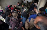 Des syriens font la queue pour recevoir à manger devant un centre gouvernemental accueillant les déplacés du fief rebelle d'Alep-Est à Jibrine, le 1er décembre 2016