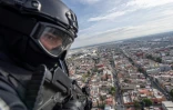 Un policier en patrouille à bord d'un hélicoptère survolant la ville de Mexico, le 2 août  2018