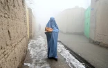 Une femme retourne à son domicile à Kaboul le 18 janvier 2022 avec du pain reçu dans le cadre d'une campagne contre la famine
