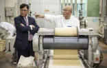 Lekh Juneja, patron d'origine indienne du fabricant japonais de snacks Kameda Seika, parle avec un employé dans le centre de tests de l'entreprise à Niigata, le 5 août 2024